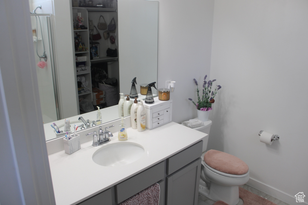 Bathroom featuring toilet, vanity, and baseboards