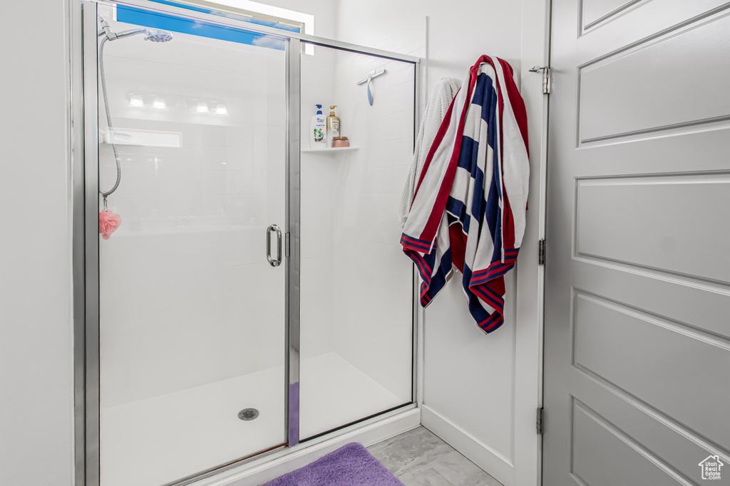 Bathroom featuring marble look tile flooring and a stall shower