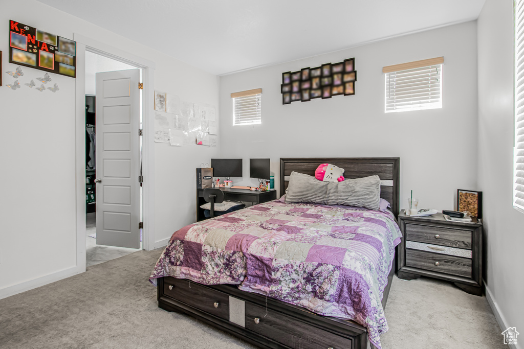 Carpeted bedroom featuring multiple windows and baseboards