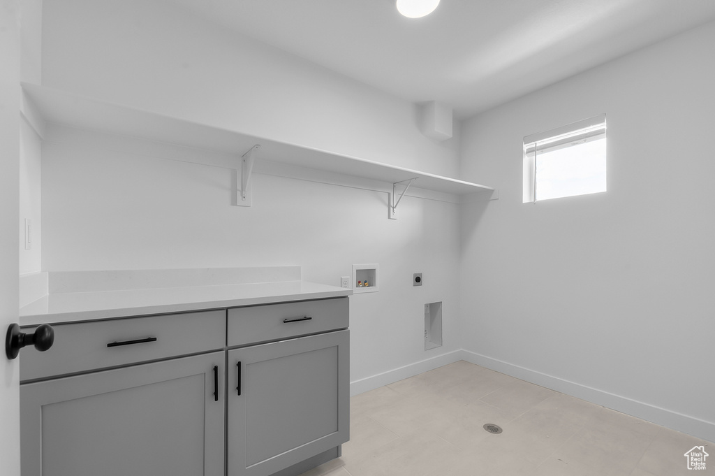 Laundry area with electric dryer hookup, washer hookup, baseboards, and cabinet space