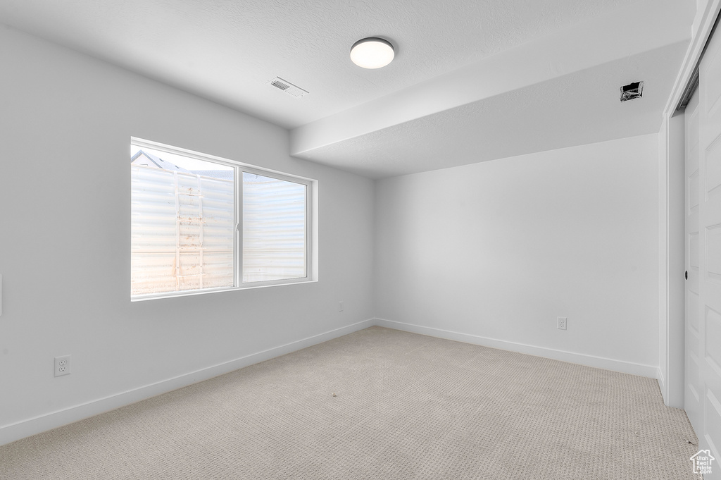 Spare room with light colored carpet and baseboards