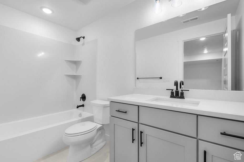 Full bathroom featuring toilet, vanity, shower / washtub combination, and tile patterned flooring