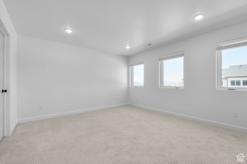 Unfurnished room featuring light colored carpet, recessed lighting, and baseboards