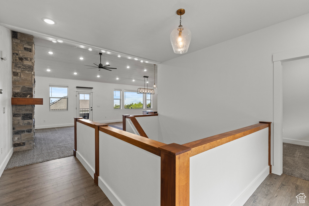 Hall with wood finished floors, recessed lighting, an upstairs landing, baseboards, and carpet