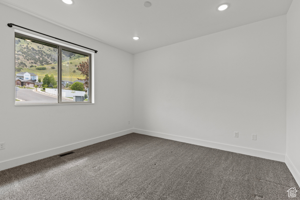Carpeted spare room featuring recessed lighting and baseboards
