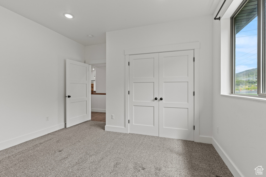 Unfurnished bedroom with carpet, baseboards, a closet, and recessed lighting