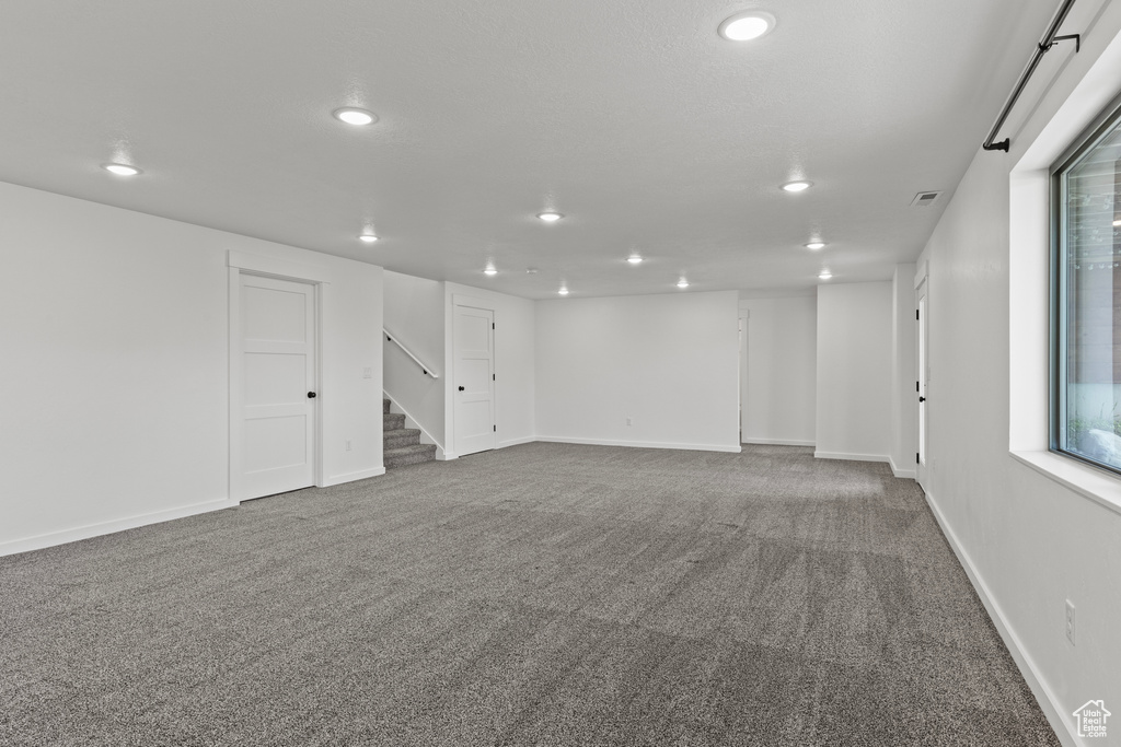 Finished below grade area featuring recessed lighting, carpet, stairs, and baseboards