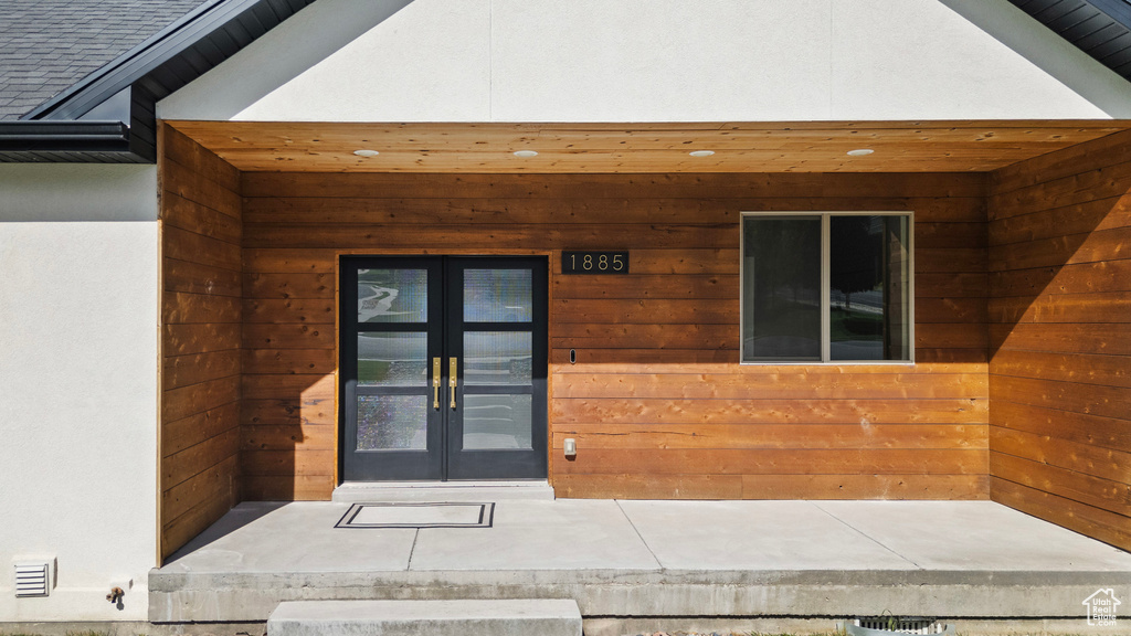 View of exterior entry with french doors and stucco siding