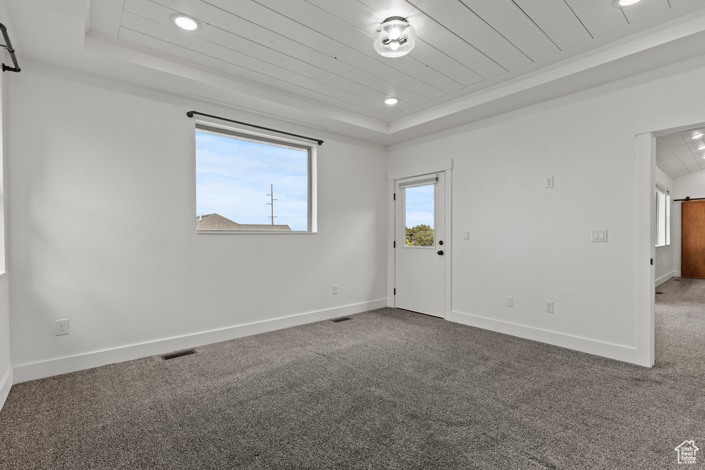 Unfurnished room with a raised ceiling, wooden ceiling, carpet floors, baseboards, and recessed lighting
