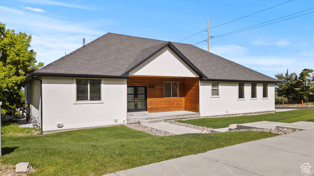 View of front facade with a front lawn and stucco siding