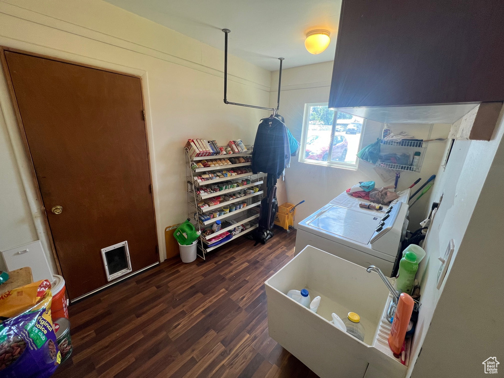 Bathroom with wood finished floors, a bathtub, and washer and clothes dryer
