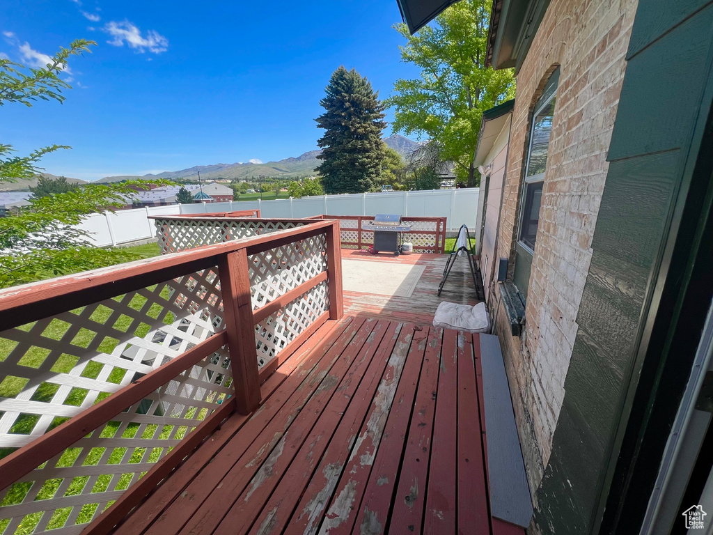 Wooden terrace with a mountain view, outdoor dining area, and fence