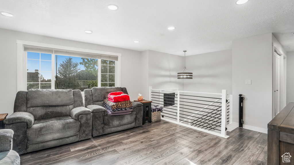 Living area with wood finished floors, recessed lighting, and baseboards