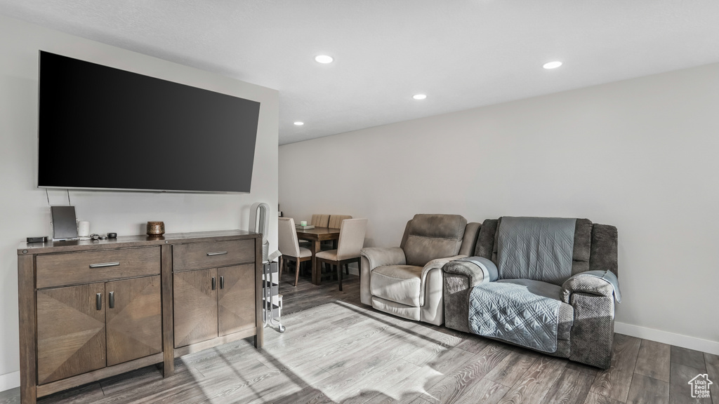 Living room with light wood finished floors, recessed lighting, and baseboards
