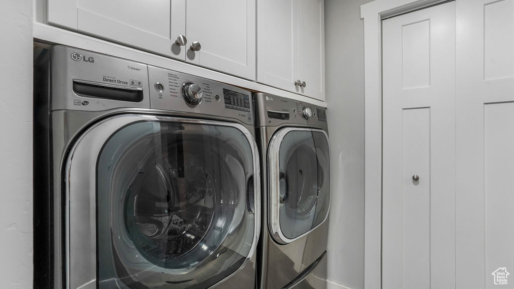 Laundry area with cabinet space, washing machine and dryer, and baseboards