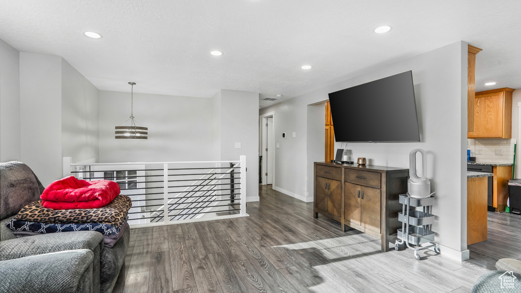 Living area with wood finished floors, recessed lighting, and baseboards