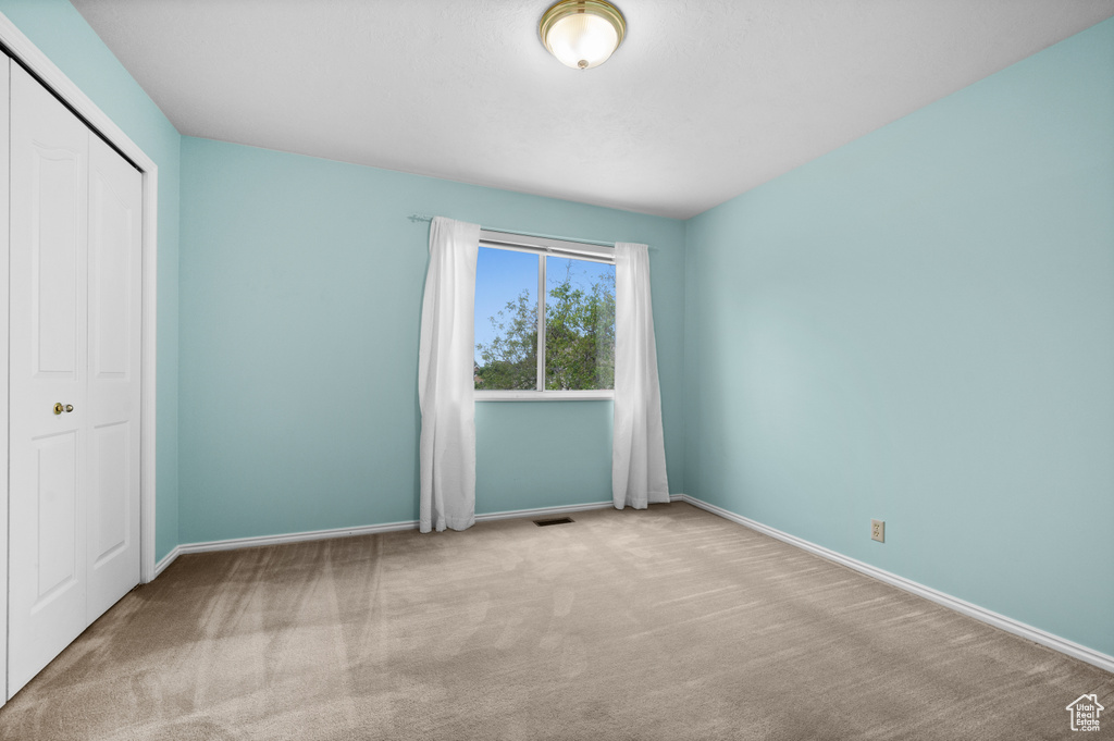 Unfurnished bedroom featuring carpet floors, baseboards, and a closet