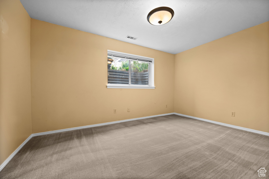 Carpeted empty room featuring baseboards