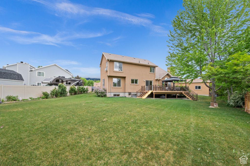Rear view of house featuring stairway, a wooden deck, a gazebo, and stucco siding