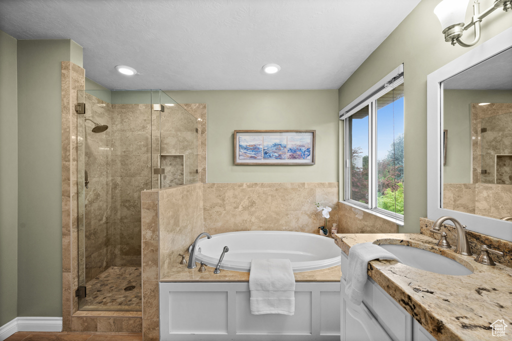 Full bath with a stall shower, a garden tub, vanity, and recessed lighting