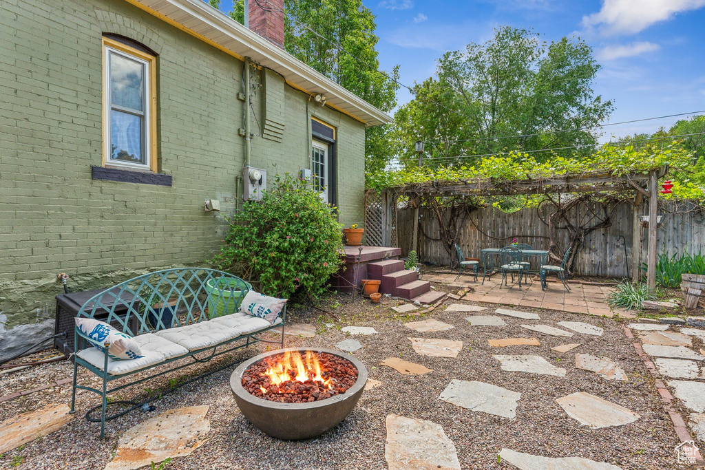 View of patio / terrace with an outdoor fire pit, outdoor dining area, and fence