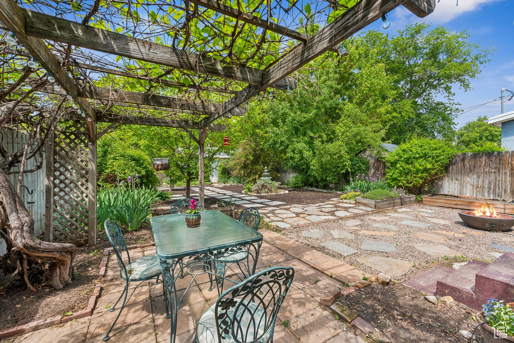 View of patio / terrace featuring a fire pit, outdoor dining space, a fenced backyard, and a pergola