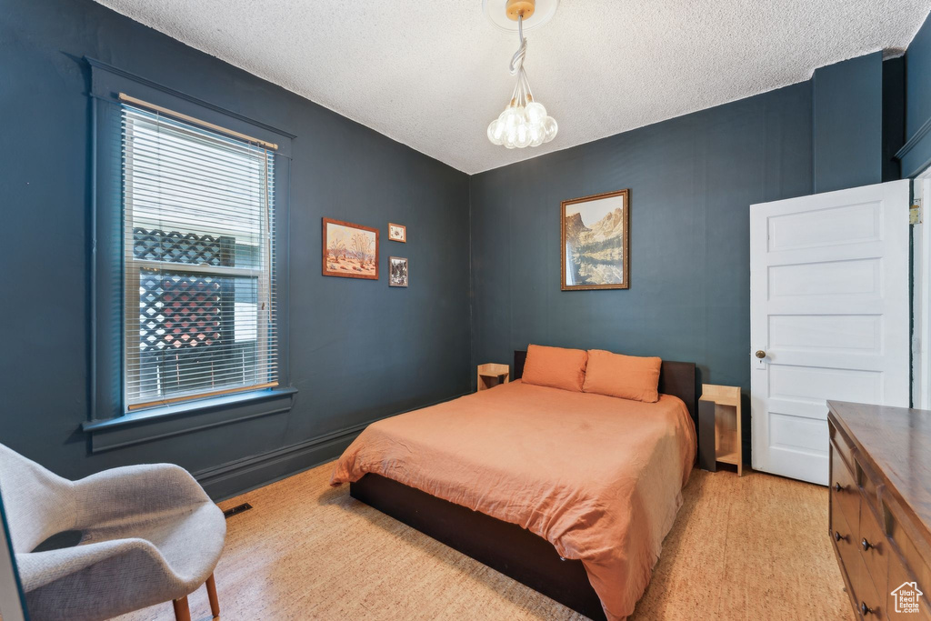Bedroom featuring a textured ceiling and a chandelier