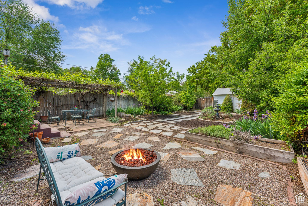 Fenced backyard with a patio area, a fire pit, and outdoor dining space