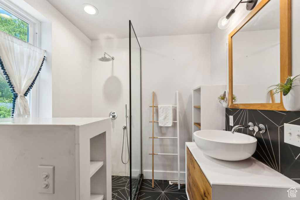 Bathroom with a walk in shower, vanity, tile patterned floors, recessed lighting, and tasteful backsplash