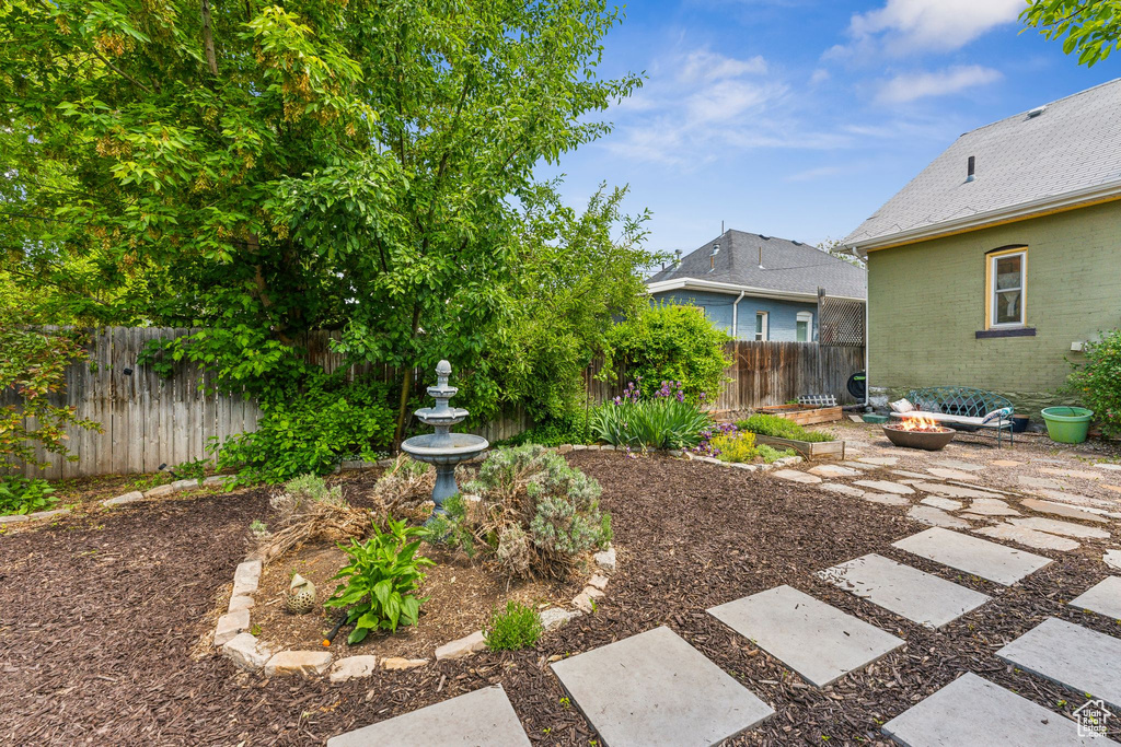 Fenced backyard featuring an outdoor fire pit and a patio area