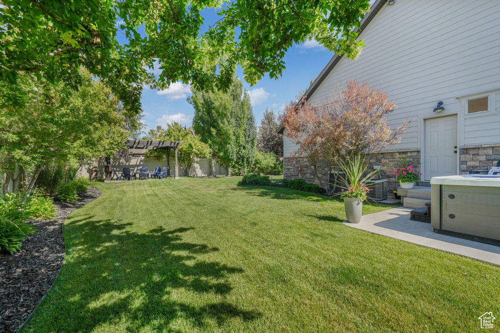 View of grassy yard featuring a pergola
