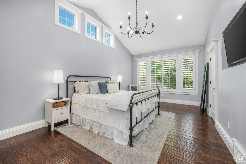 Bedroom with a chandelier, multiple windows, wood-type flooring, and high vaulted ceiling