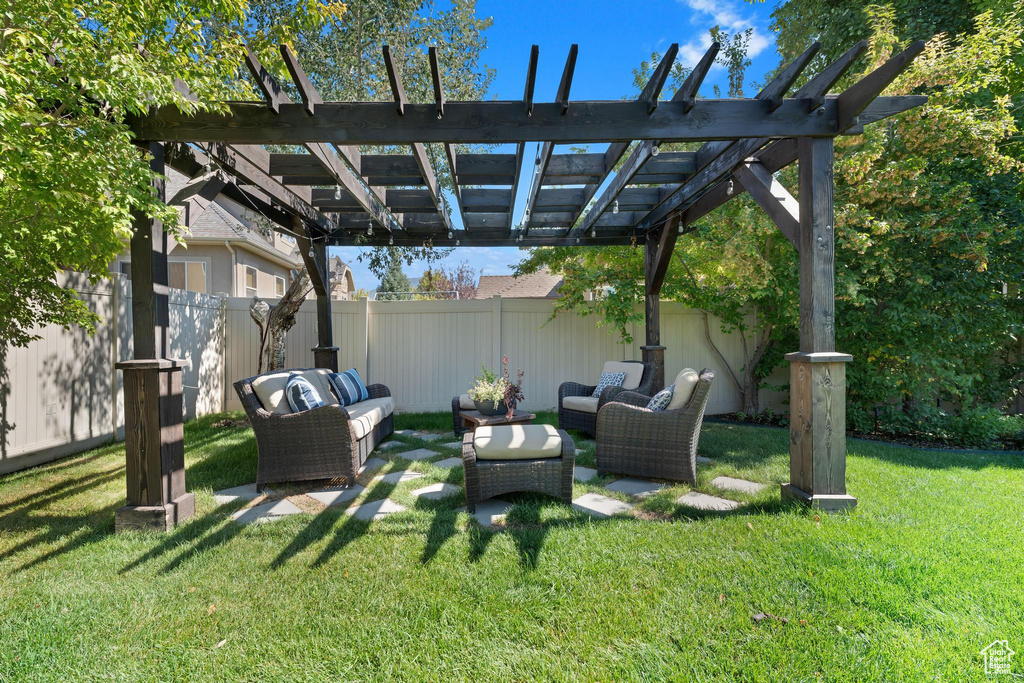 View of yard with an outdoor living space and a pergola