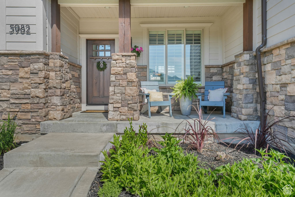 Entrance to property with stone siding and covered porch