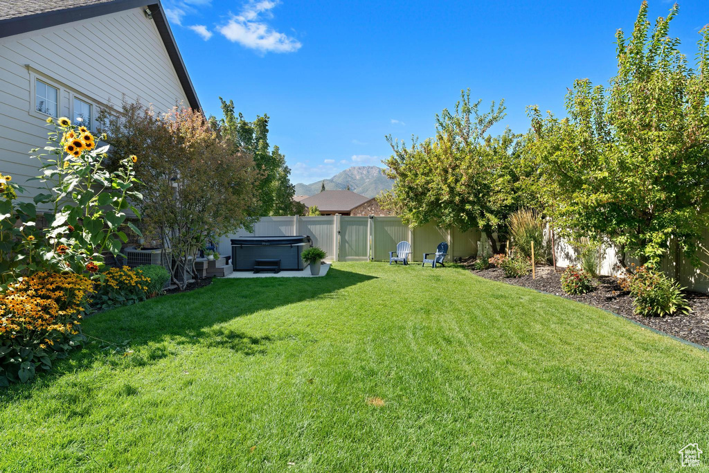 View of yard with a hot tub and a mountain view