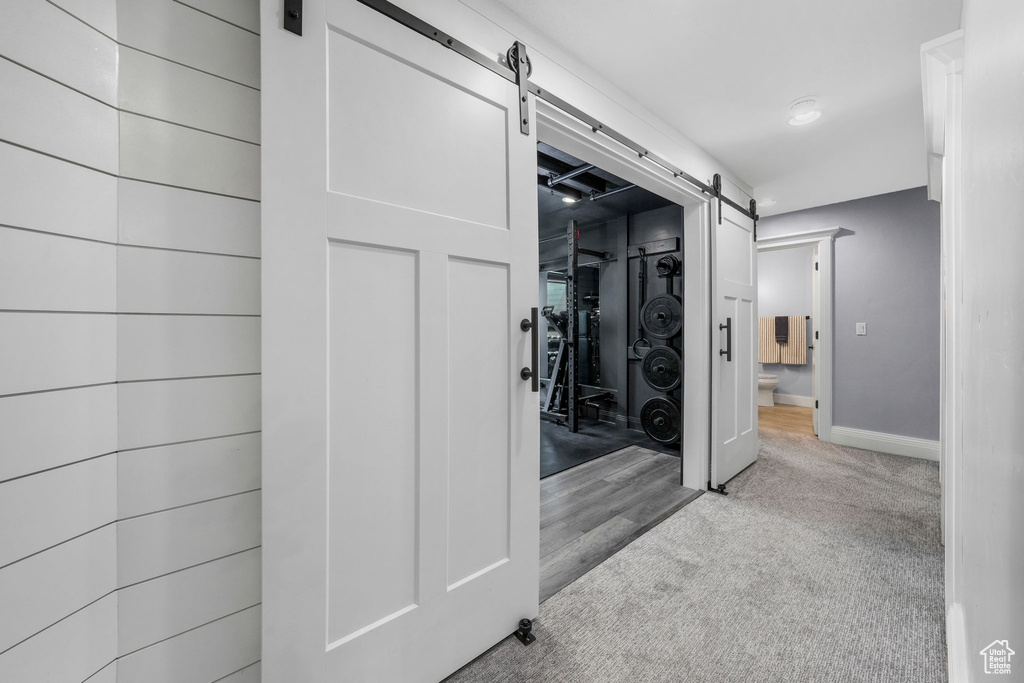Hallway with a barn door, carpet flooring, and recessed lighting