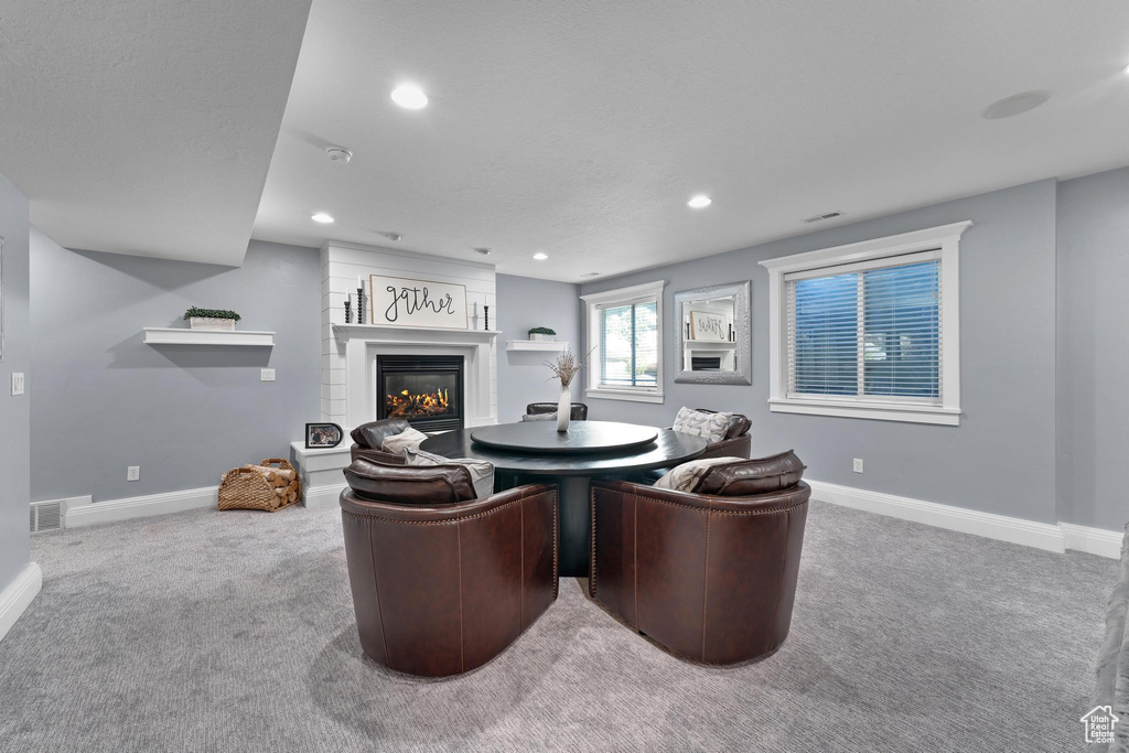 Living room with carpet flooring, a glass covered fireplace, baseboards, and recessed lighting
