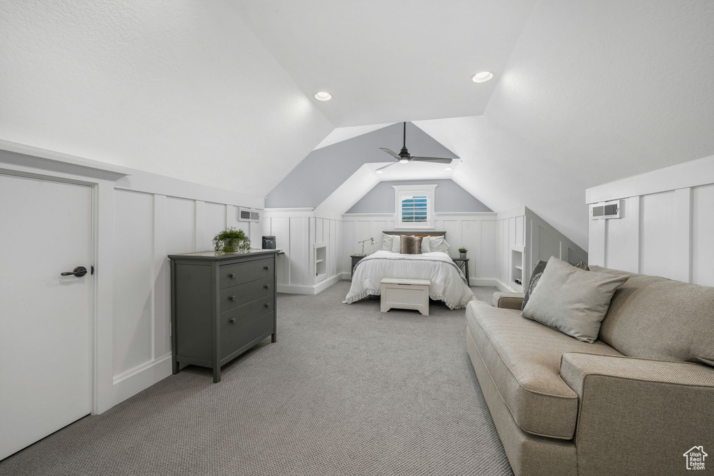 Bedroom featuring light carpet, a decorative wall, vaulted ceiling, and ceiling fan