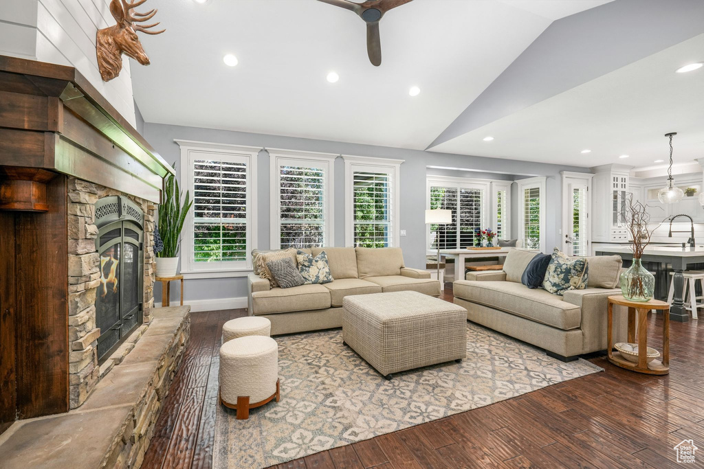 Living area with vaulted ceiling, a fireplace, ceiling fan, hardwood / wood-style floors, and recessed lighting