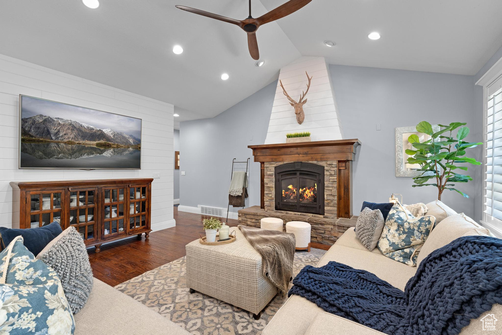 Living room with a ceiling fan, wood finished floors, a lit fireplace, recessed lighting, and vaulted ceiling