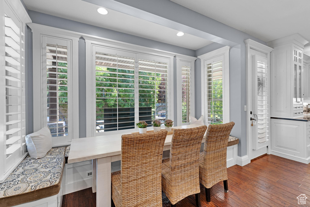 Dining area with dark wood-style flooring, healthy amount of natural light, recessed lighting, and baseboards