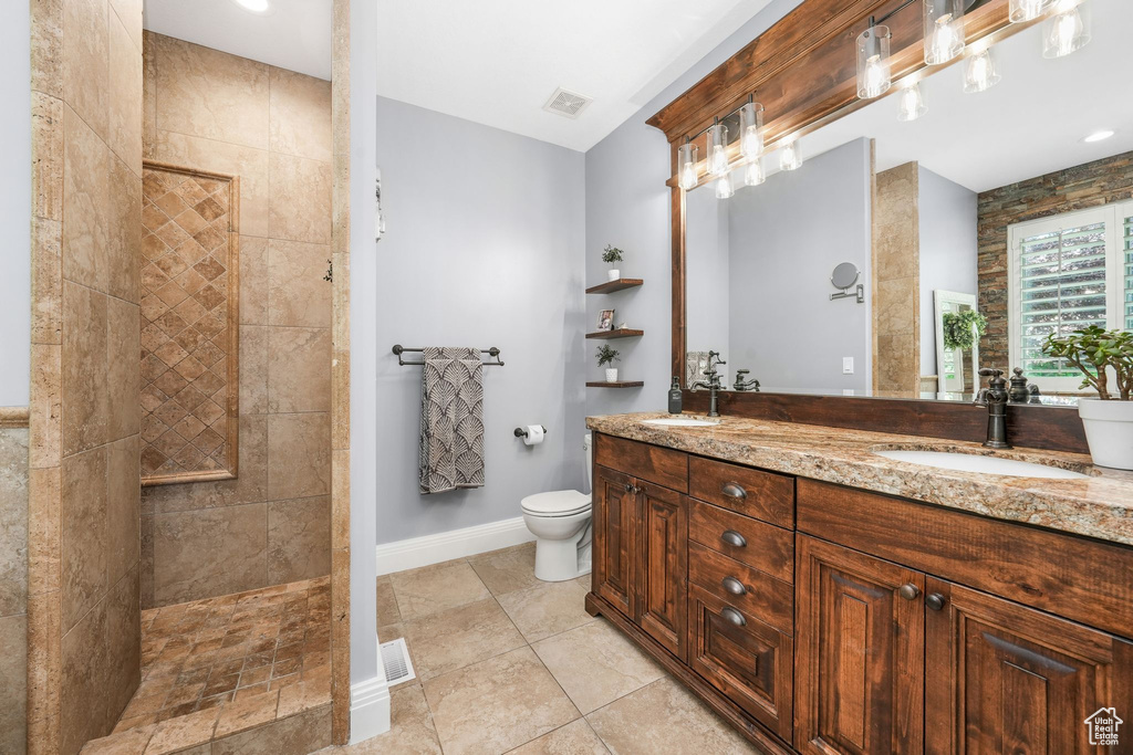 Full bath featuring double vanity, a walk in shower, and tile patterned flooring