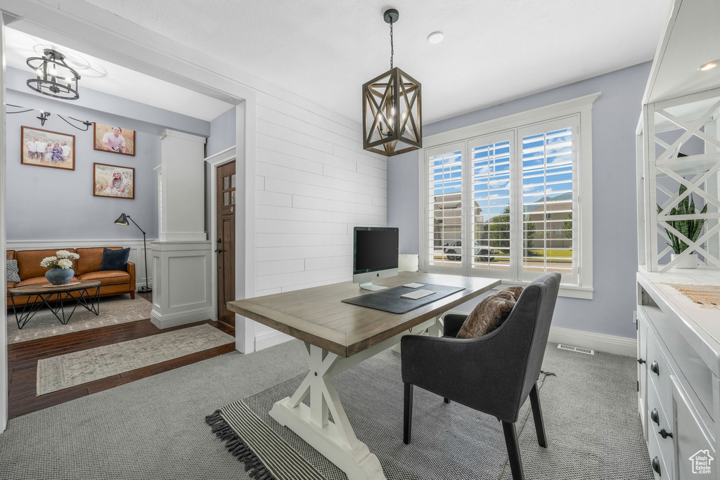 Office area featuring light carpet and a chandelier
