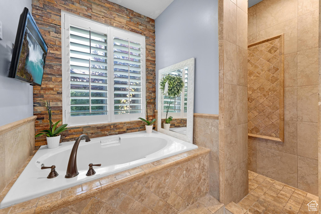 Bathroom with plenty of natural light, a bath, and a walk in shower