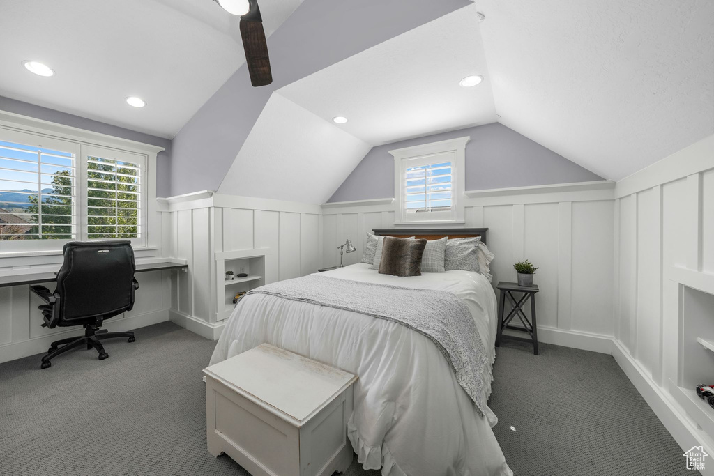 Bedroom with a decorative wall, carpet, vaulted ceiling, wainscoting, and ceiling fan