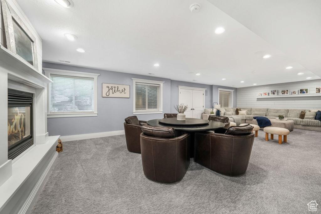 Living area with carpet floors, recessed lighting, and a glass covered fireplace