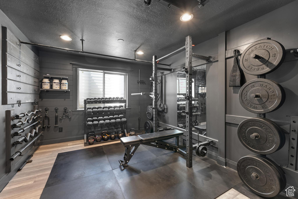 Workout room featuring a textured ceiling, recessed lighting, and wood finished floors