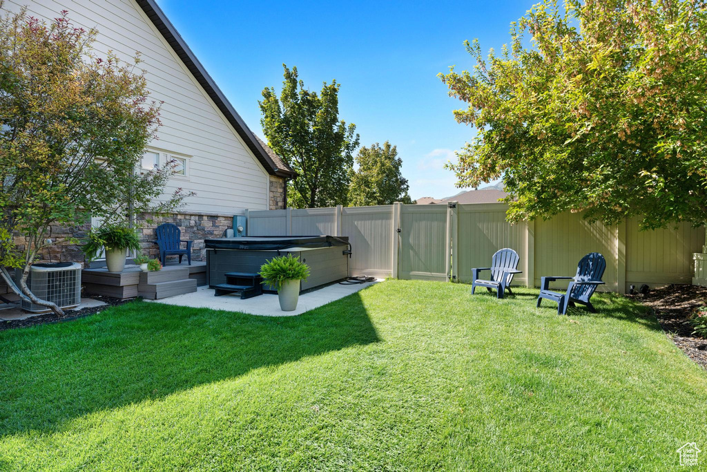 View of yard featuring a hot tub and central air condition unit