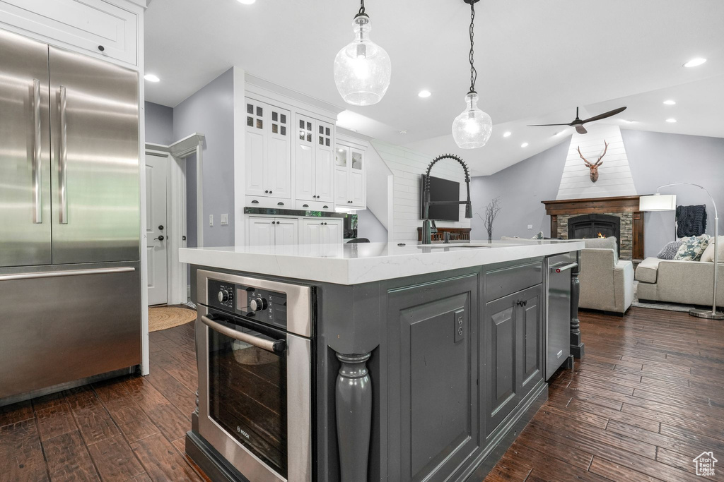 Kitchen with appliances with stainless steel finishes, white cabinets, dark wood-style floors, gray cabinetry, and recessed lighting
