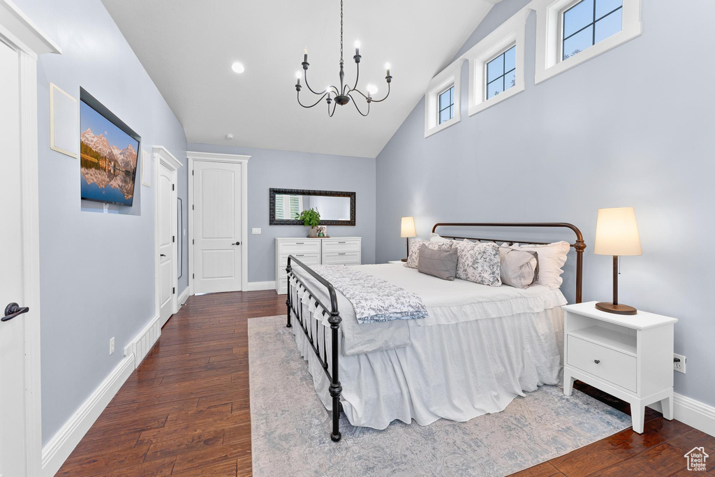 Bedroom featuring high vaulted ceiling, a chandelier, dark wood-style flooring, and baseboards